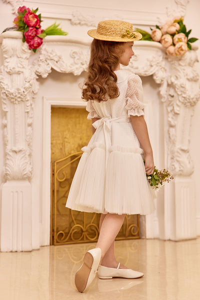 White tulle dress with green bow and flower